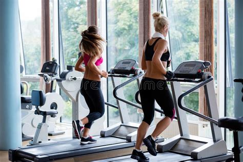 Amigos Que Exercitam Em Uma Escada Rolante No Gym Moderno Brilhante