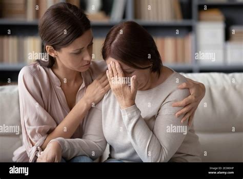 Close Up Caring Grownup Daughter Comforting Unhappy Mature Mother Stock