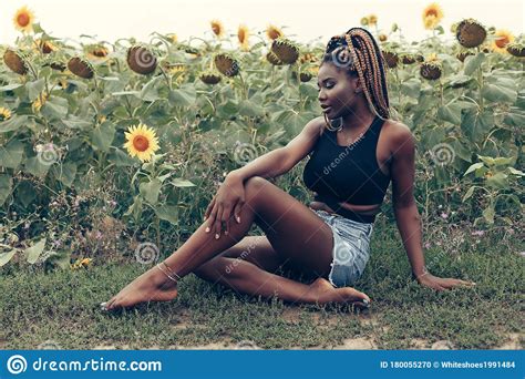 African American Girl In A Field Of Yellow Flowers At Sunset Stock