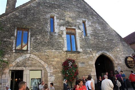 People Are Standing Outside An Old Stone Building With Wreaths On The