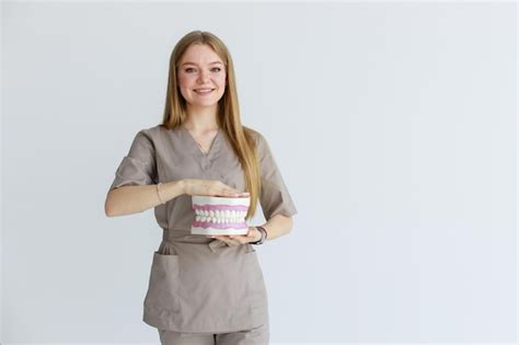 Premium Photo | Orthodontist in medical uniform fixing girl39s dental ...