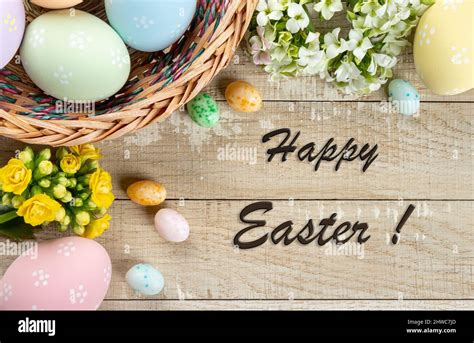 Easter border of colored easter eggs and flowers on a rustic wooden ...