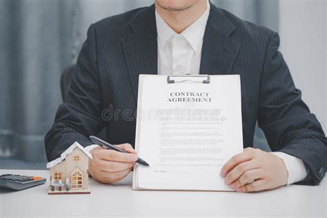 Real Estate Agent Showing Contract Agreement At Office Home Sales And Home Insurance Concept