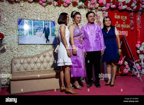 Two Women Pose For A Photo Beside The Bride And Groom At A Traditional