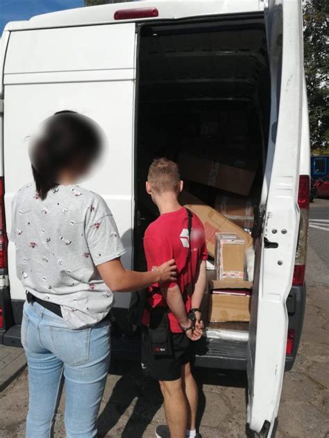 A Man And Boy Loading Boxes Into The Back Of A White Van With Its Door Open