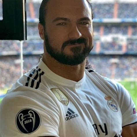 A Man With A Goatee Standing In Front Of A Stadium