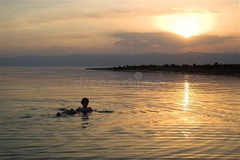 Mulher Que Flutua No Mar Morto No Por Do Sol Imagem De Stock Imagem