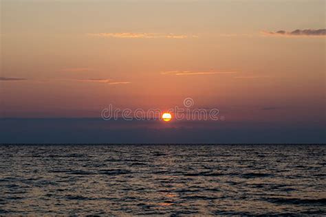 The Bright Red Sun Sets Over The Sea Horizon Stock Photo Image Of