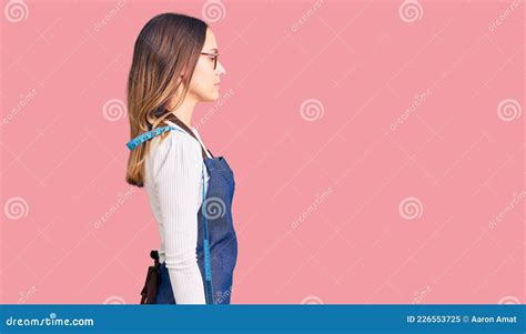 Linda Jovem Brunette Costureira Vestindo Avental Atelier Que Olha Para O Perfil De Relaxamento