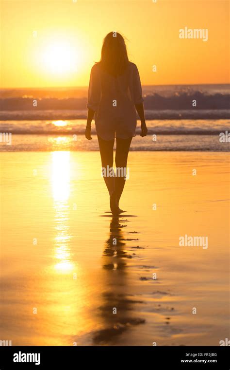 Lady Walking On Sandy Beach In Sunset Stock Photo Alamy