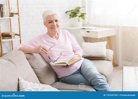 Senior Woman Resting On Sofa And Reading Book Stock Image Image Of