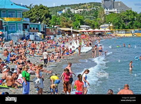 ALUSHTA, CRIMEA, UKRAINE - People on the public pebble beach near Black ...