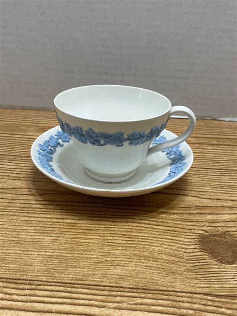 A Cup And Saucer Sitting On Top Of A Wooden Table