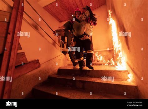 Brave Fireman Descends Stairs Of A Burning Building And Holds Saved