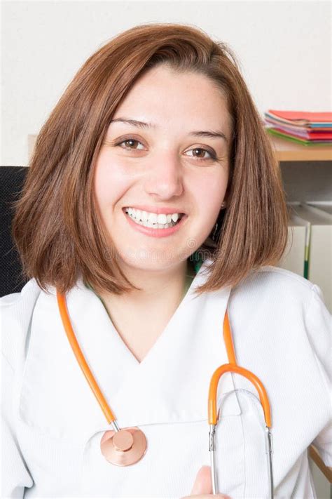 Young Woman Doctor With White Coat Sitting In Office Hospital Stock