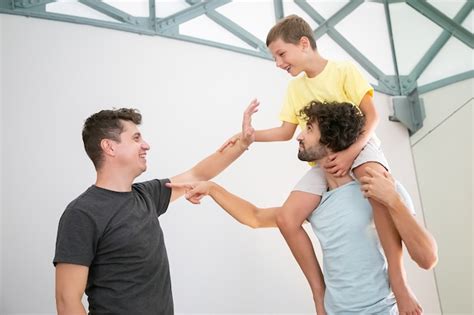 Heureux Couple Gay Et Leur Fils Joyeux S amusant à La Maison Jouant à Des Jeux Actifs Garçon à