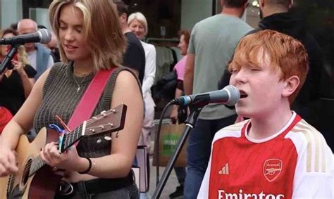 Un Gar On De Ans Se Joint Une Musicienne Dans Une Rue Pour Chanter