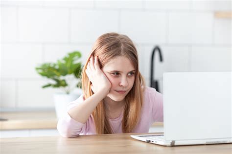 Gadis Remaja Bingung Duduk Di Meja Menggunakan Laptop Belajar Online Di
