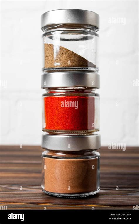 Bright Fragrant Spices In Glass Jars Of Different Sizes On A Wooden