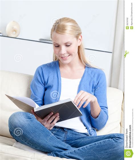 Le Beau Femme Affiche Le Livre Se Trouvant Sur Le Sofa Photo Stock