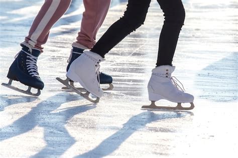 Pies De Diferentes Personas Patinando En La Pista De Hielo Foto Premium