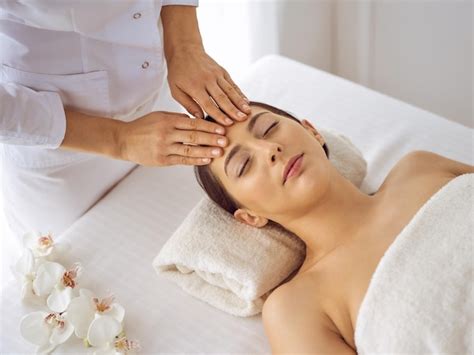 Premium Photo Beautiful Brunette Woman Enjoying Facial Massage With Closed Eyes Relaxing