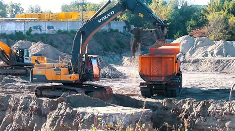 The Excavator Loading Crushed Stone Into A Dump Truck In A Crushed