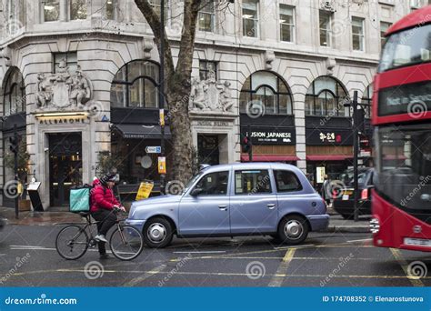 Red Bus And Black Taxi On A Background Of A Gray Building Editorial