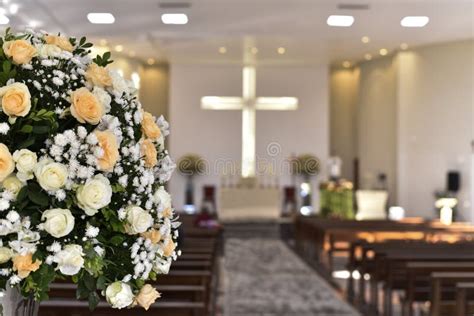 Catholic Church Prayer Altar With Flower Arrangements And Cross In The