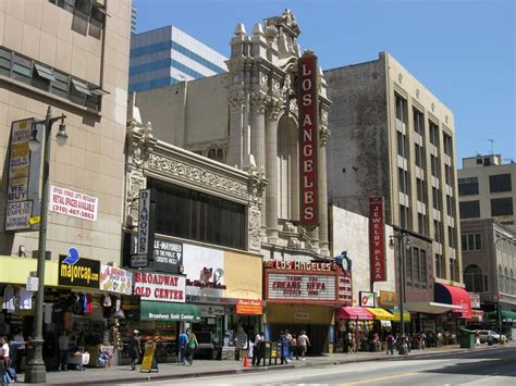 People Are Walking Down The Street In Front Of Some Buildings