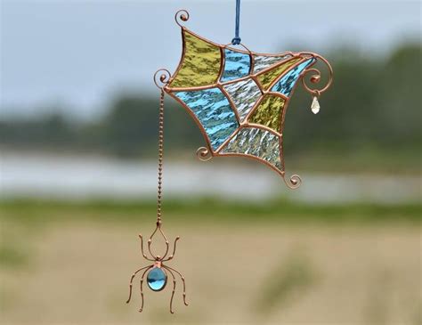 A Stained Glass Wind Catcher With A Spider Hanging From It S Side On A