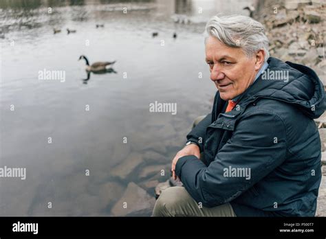 Senior Man At The Riverside Looking Sideways Stock Photo Alamy