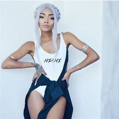 A Woman With White Hair Wearing A Skirt And Tank Top Posing For The Camera