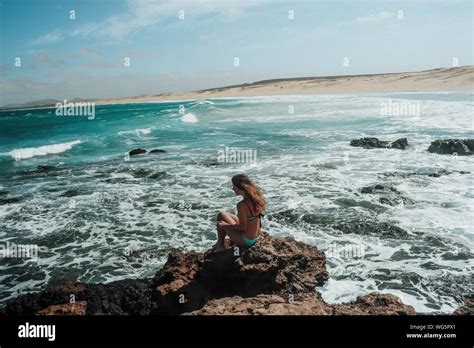 Woman wearing bikini sitting on Fotos und Bildmaterial in hoher Auflösung Alamy