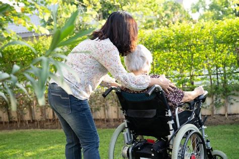 Cuidador Ayuda Y Cuida A Una Anciana Asi Tica Sentada En Silla De