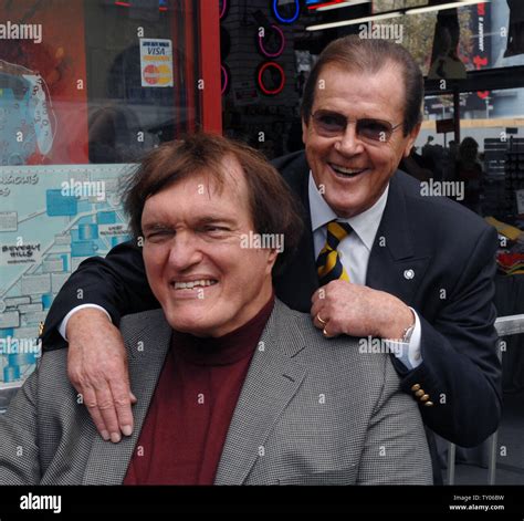 British Actor Roger Moore R Who Played The Part Of James Bond 007 In Seven Films Poses With