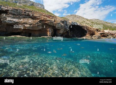 Sea Cave On The Mediterranean Coast In Spain With A Shoal Of Fish