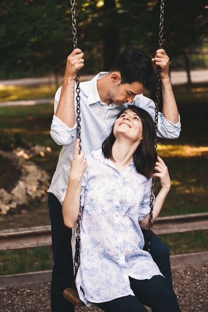 Sonriente Pareja De Enamorados En Un Columpio Al Aire Libre Foto Gratis