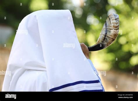 Jewish Man In Tallit Blowing Shofar Outdoors Rosh Hashanah Celebration