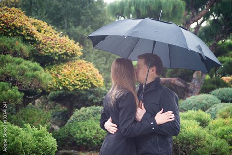 Couple Kissing In The Rain With Umbrella