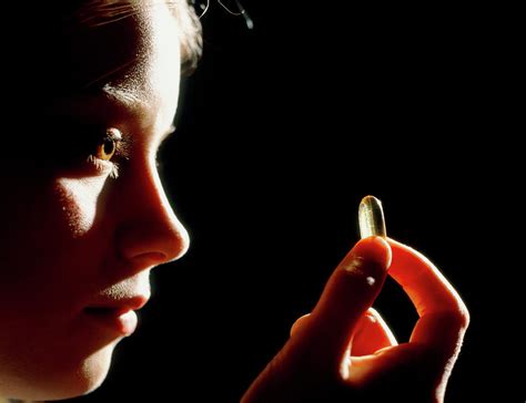 Woman Holding An Evening Primrose Oil Capsule Photograph By Damien Lovegrove Science Photo