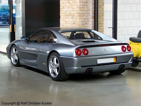 a silver sports car parked in front of a brick wall and glass doored ...