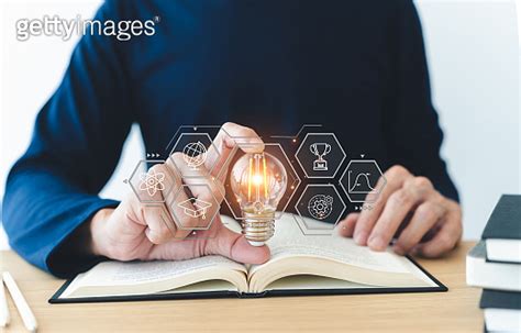 Student Holding Bright Lightbulb And Reading Book Or Textbook Success