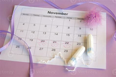 Menstrual Pads And Tampons On Menstruation Period Calendar With On Lilac Background 36037883