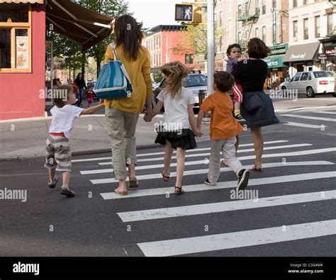 Children Hold Hands While Crossing A Street In Brooklyn New York Stock