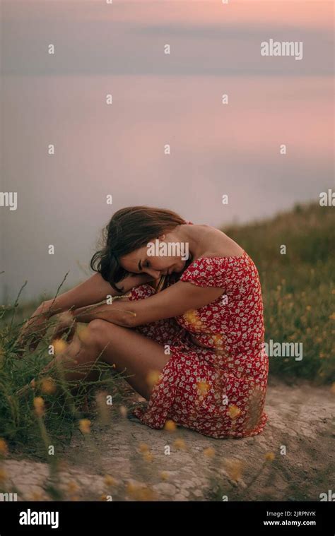 Portrait Girl In Summer On Mountain With Her Head Bowed On Her Knees