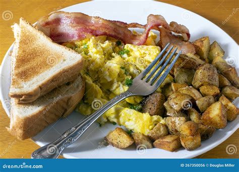 Breakfast Plate Of Scramble Eggs And Bacon With Homefries Stock Photo