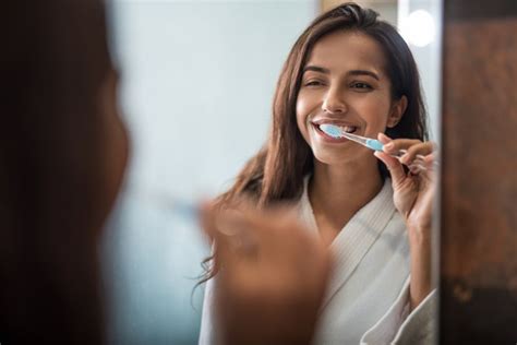 Woman Smiling While Brushing Her Teeth James T Gray Dds Blog