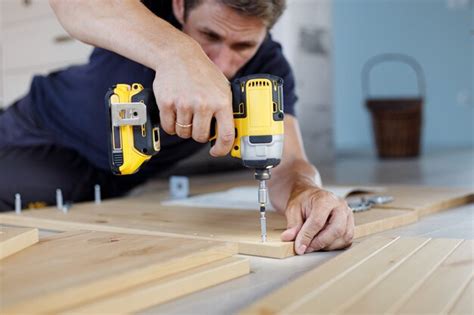 Premium Photo Man Assembling Furniture At Home Using A Cordless