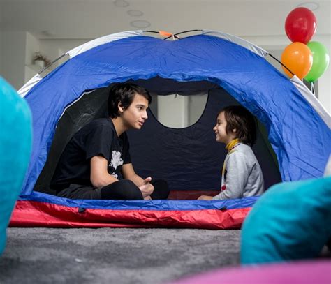 Niños con tienda de campaña en la sala de estar para divertirse y